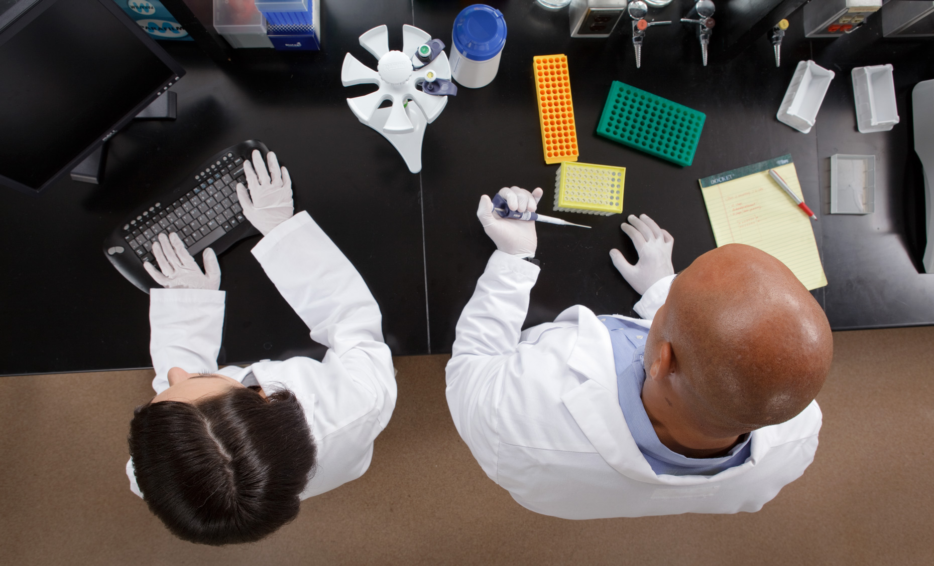 Overhead view of two people working in a laboratory.