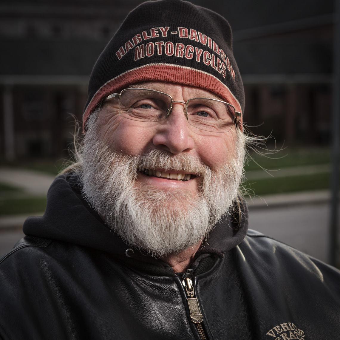 Bearded man with Harley Davidson Hat smiling.