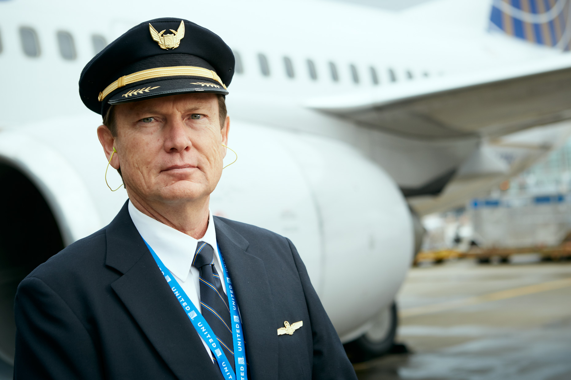Male airline pilot standing aside the airplane.