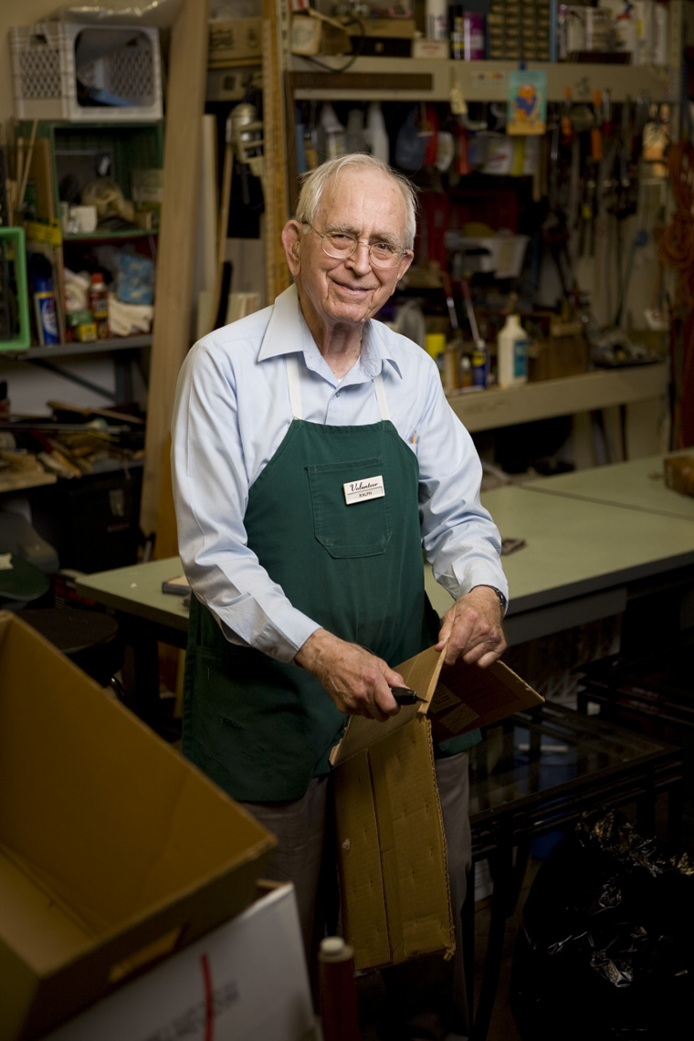 Man wearing green apron working in a warehouse.